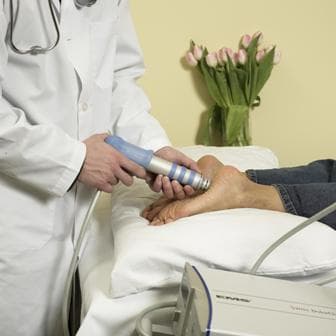 A doctor performs ESWT/EPAT on a patient
